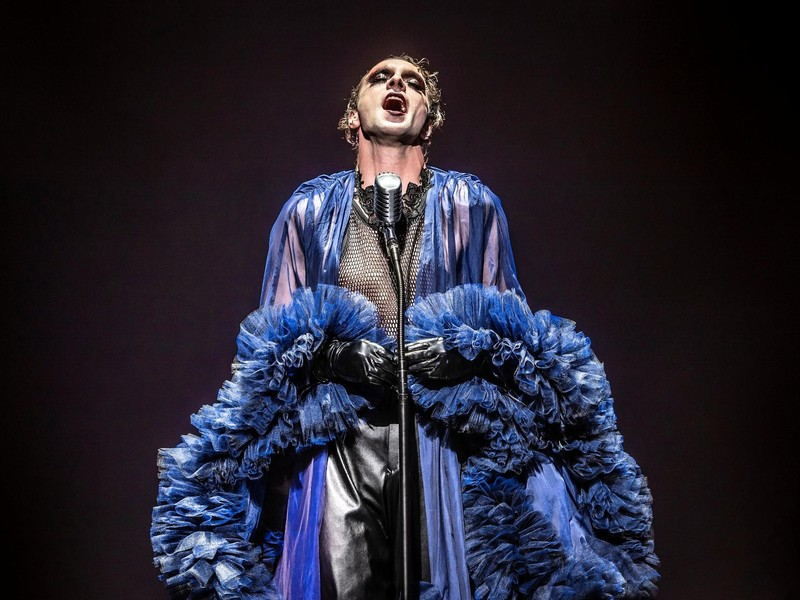 André Kaczmarczyk: The Actor Redefining Modern German Crime Drama
A Performer at the Center of Germany’s Evolving Screen Culture
In contemporary German television and theatre, few actors have navigated both traditional performance and modern storytelling as effectively as André Kaczmarczyk. Known for his versatility and depth, Kaczmarczyk has steadily built a career that spans classical theatre, experimental productions, and mainstream television.
His recent prominence—particularly through his role as Chief Inspector Vincent Ross in Polizeiruf 110—positions him not only as a recognizable face in German entertainment but also as a figure reflecting broader cultural and narrative shifts in European media.
From Eisenach to the Stage: Early Foundations
Born on March 11, 1986, in Suhl, Germany, Kaczmarczyk grew up in Eisenach, where his artistic inclinations developed early. His formative years were closely tied to theatre, beginning with youth productions and performances at institutions such as the Freien Eisenacher Burgtheater and Landestheater Eisenach.
His early exposure to performance was not casual—it was disciplined and continuous. Notably, he portrayed Martin Luther in a historical open-air festival shortly after completing his secondary education, signaling both his commitment and early recognition in performance circles.
This early immersion established two defining traits of his career:
A strong grounding in classical and historical storytelling
A willingness to engage with complex, character-driven narratives
Professional Training and Theatre Breakthrough
Kaczmarczyk formalized his craft at the prestigious Ernst Busch Academy of Dramatic Arts in Berlin, one of Germany’s leading acting institutions. During and after his studies, he appeared in a range of productions, including adaptations of works by Georg Büchner and William Shakespeare.
His theatre career developed rapidly:
Early professional engagements at the Hans Otto Theater in Potsdam
Performances at the Maxim Gorki Theater in Berlin
A significant tenure at Staatsschauspiel Dresden, where he became a permanent ensemble member
At Dresden, he demonstrated notable range—playing roles from Shakespearean characters to contemporary theatrical works. His performances often explored identity, transformation, and psychological depth, themes that would later define his television roles as well.
By 2016, he transitioned to the Düsseldorfer Schauspielhaus, further consolidating his reputation as a leading stage actor in Germany.
Expanding Creative Scope: Actor, Writer, and Director
Unlike many actors who remain confined to performance, Kaczmarczyk has also worked as a creator. He has written and staged productions, often incorporating musical and experimental elements.
Among his notable creative contributions:
Heart of Gold, an ensemble recital
A scenic installation based on Jeff Koons
A musical adaptation of Alice, premiered in Düsseldorf
These projects demonstrate a broader artistic philosophy—one that treats theatre not merely as performance but as a multidisciplinary platform.
His continued innovation earned him a nomination for the prestigious Faust Award in 2024, underscoring his influence within German theatre.
Transition to Screen: Film and Television Career
While theatre remains central to his identity, Kaczmarczyk has steadily built a screen presence across film and television.
His early roles included:
Portraying King Ludwig II in the historical series Die Deutschen
Appearances in the film Anonymus
Roles in German crime series such as Die Chefin and In aller Freundschaft – Die jungen Ärzte
These roles, though varied, consistently highlighted his ability to inhabit psychologically nuanced characters—often balancing emotional subtlety with narrative tension.
The Defining Role: Vincent Ross in Polizeiruf 110
Kaczmarczyk’s breakthrough in mainstream recognition came with his casting as Vincent Ross in Polizeiruf 110, one of Germany’s longest-running crime series.
Introduced in 2022, Ross stands out for several reasons:
He is the first gender-fluid commissioner in the series
His investigative style emphasizes empathy and introspection
The character challenges traditional portrayals of detectives in crime dramas
In the 2026 episode Goldraub, Ross—alongside Karl Rogov—investigates the murder of a goldsmith in Potsdam, uncovering a complex case involving insider knowledge and stolen historical artifacts.
The episode reflects a broader narrative shift: away from high-action crime storytelling toward quieter, character-driven investigations.
Audience Reception: A Divided but Engaged Viewership
The reception to Kaczmarczyk’s performance in Polizeiruf 110: Goldraub has been notably polarized.
Many viewers praised his portrayal:
“Detective Ross is absolutely convincing… empathetic and captivating.”
“He’s simply a pleasure to watch… the suspense was very well built.”
Others, however, criticized aspects of the show’s pacing and thematic focus, particularly its emphasis on social issues.
This divergence is significant. It indicates that Kaczmarczyk’s work is not merely entertaining—it is provocative, prompting discussion about:
Representation in media
The evolution of crime storytelling
Audience expectations in public broadcasting
Cultural Impact: Redefining the Crime Drama Archetype
Kaczmarczyk’s portrayal of Vincent Ross represents a broader transformation in European television.
Traditional crime dramas often center on:
Action-driven narratives
Emotionally detached investigators
Formulaic plot structures
By contrast, Ross embodies:
Emotional intelligence
Fluid identity
A collaborative, human-centered approach to investigation
This shift aligns with contemporary cultural trends that prioritize authenticity, diversity, and psychological realism.
Beyond Acting: Radio, Social Engagement, and Artistic Advocacy
In addition to stage and screen work, Kaczmarczyk has contributed to radio productions for institutions such as Rundfunk Berlin-Brandenburg and BBC Radio.
He has also engaged in socially conscious projects, including theatrical readings addressing humanitarian issues in the Mediterranean.
These activities suggest an artist who views performance as a tool for reflection and dialogue—not merely entertainment.
What Lies Ahead: Future Trajectory
At 40, Kaczmarczyk stands at a mature phase of his career—one characterized by both stability and expansion.
Several potential trajectories are evident:
Continued prominence in television, particularly within Polizeiruf 110
Further exploration of directing and writing, building on his theatrical work
Increased international exposure, given growing recognition and critical acclaim
Audience commentary has already hinted at broader potential, with some viewers speculating about opportunities beyond German television.
Conclusion: A Career Defined by Range and Relevance
André Kaczmarczyk’s career illustrates a rare balance between tradition and innovation. From early theatre roots in Eisenach to national recognition on television, his trajectory reflects both discipline and adaptability.
His work—particularly as Vincent Ross—signals a shift in how stories are told and who gets to tell them. It is not simply about solving crimes on screen; it is about reshaping the emotional and cultural language of storytelling itself.
In an industry often driven by formulas, Kaczmarczyk’s approach stands out for its nuance, experimentation, and relevance.