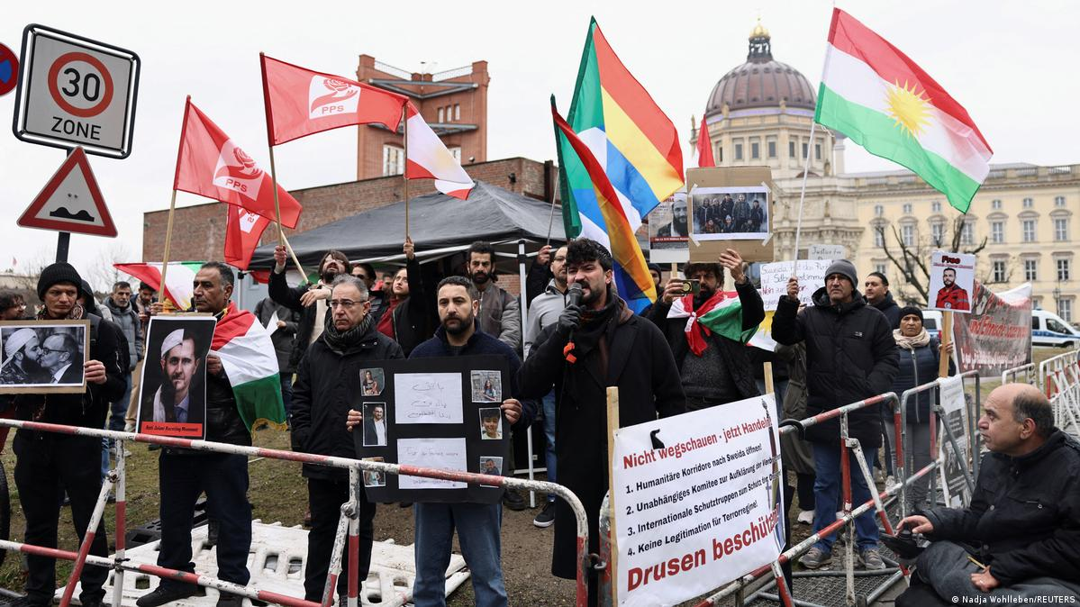 Syria at a Crossroads: Reconstruction, Returns, and Rising Controversy 4 Introduction: A Nation Re-emerging into Global Focus More than a decade after the outbreak of civil war in Syria, the country is once again at the center of international attention. Recent diplomatic developments, economic discussions, and security cooperation efforts suggest a shift in how global powers are engaging with Damascus. At the heart of this renewed focus is the controversial leadership of interim president Ahmed al-Sharaa and a growing willingness from European nations—particularly Germany—to re-engage with Syria politically and economically. This moment reflects a complex intersection of reconstruction ambitions, refugee policies, and geopolitical realities. A Diplomatic Reset: Germany and Syria Rebuild Ties One of the most significant recent developments is Germany’s effort to deepen cooperation with Syria, signaling a notable shift in European foreign policy. German Foreign Minister Johann Wadephul emphasized that Syria holds “enormous” potential as both a market and a production partner. He described the country as a “strategic hub between Europe, the Gulf states and the Indo-Pacific,” highlighting its geographic and economic relevance. This positioning suggests that Syria is no longer viewed solely through the lens of conflict but increasingly as a future economic partner. At a high-level economic forum in Berlin, German officials pledged support for: Rebuilding Syrian state institutions Supporting economic recovery Expanding bilateral trade opportunities Despite ongoing regional instability, Wadephul acknowledged that Syria has managed to prevent broader conflict spillover—calling it “a great success” given tensions across the Middle East. The Al-Sharaa Factor: Leadership, Legitimacy, and Criticism The visit of Ahmed al-Sharaa to Berlin marked a turning point—but also sparked controversy. 4 Al-Sharaa, a 43-year-old former militia leader, has a complex and contentious background. He previously commanded the al-Nusra Front, once linked to extremist networks. His rise to power following the overthrow of Bashar al-Assad in late 2024 has divided international opinion. While some governments see him as a necessary partner for stabilization, critics highlight: Allegations of human rights violations Concerns about minority protection Questions about democratic legitimacy His reception in Berlin reflected this divide. Supporters gathered enthusiastically, chanting “Allahu Akbar,” while protests and political criticism underscored deep unease about legitimizing his leadership. Even within Germany, political and civil society groups remain split. Some argue engagement is essential for peacebuilding, while others warn it risks compromising democratic values. Refugee Returns: Policy, Pressure, and Reality A central issue shaping Germany-Syria relations is the question of refugee repatriation. Germany currently hosts approximately 1 million Syrians, many of whom fled the civil war beginning in 2011. Chancellor Friedrich Merz has proposed an ambitious plan: 80% of Syrians in Germany should return within three years A joint task force will coordinate repatriation efforts Financial support—around €200 million—will assist Syria’s reconstruction However, the policy remains highly controversial. Key Challenges to Repatriation Security concerns: Conditions in Syria are still described as “volatile” Infrastructure damage: Many areas remain heavily destroyed Economic hardship: Limited access to jobs, food, and services Legal risks: Refugees who return may lose protected status abroad Non-governmental organizations have strongly cautioned against forced returns, arguing that safe and dignified conditions are not yet guaranteed. Reconstruction and Economic Opportunity Despite ongoing challenges, Syria is actively positioning itself for reconstruction and investment. Al-Sharaa has framed the country as entering a “new beginning,” emphasizing: Legal reforms to attract foreign investment Opportunities in energy, construction, and technology Efforts to stabilize governance structures Germany and other partners see potential in sectors such as: Infrastructure rebuilding Industrial production IT and software development Energy systems modernization This aligns with broader geopolitical dynamics, where Syria could serve as a logistical and economic bridge between regions. Security Developments: Intelligence and Regional Cooperation Recent events also highlight growing cooperation on security matters. In a notable operation, Turkish intelligence—working with Syrian authorities—captured a fugitive spy at the Syria-Lebanon border after more than a decade on the run. The case underscores: Increasing coordination between regional intelligence agencies Syria’s evolving role in cross-border security Ongoing concerns about espionage and militant networks Such developments suggest that beyond reconstruction, Syria remains a critical player in regional stability and intelligence dynamics. A Fragile Stability in a Volatile Region Despite signs of progress, Syria’s situation remains deeply complex. German officials acknowledge that while conditions have “fundamentally improved,” the broader environment is still unstable. Key risks include: Spillover from regional conflicts (including tensions involving Iran) Internal political fragmentation Ongoing humanitarian challenges Ethnic and sectarian tensions At the same time, Syria has managed—so far—to avoid being drawn into escalating regional conflicts, which some leaders view as a sign of cautious stabilization. What Comes Next: A Critical Turning Point Syria now stands at a pivotal moment. Three parallel trajectories are shaping its future: Reconstruction and economic reintegration Refugee return and demographic shifts Political legitimacy and governance reform The success—or failure—of these efforts will determine whether Syria can transition from a post-conflict state into a stable and functioning nation. Conclusion: Between Opportunity and Uncertainty The re-engagement between Syria and international partners marks a significant shift in global attitudes. Economic cooperation, refugee policy, and security collaboration all point toward a country attempting to rebuild and redefine its role. Yet, the path forward remains uncertain. The leadership of Ahmed al-Sharaa continues to divide opinion, while the realities on the ground challenge optimistic timelines for recovery and repatriation. Syria’s future will depend not only on international support but also on its ability to address internal divisions, rebuild trust, and create conditions for a genuinely inclusive and stable society.