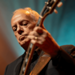 Peter Frampton returns with “Carry The Light” in 2026. Explore his comeback, health battle, and legacy in this in-depth feature.